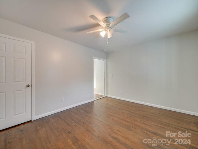 empty room with ceiling fan and dark hardwood / wood-style flooring