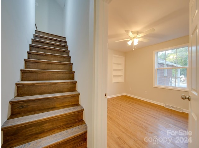 stairway with ceiling fan and hardwood / wood-style floors