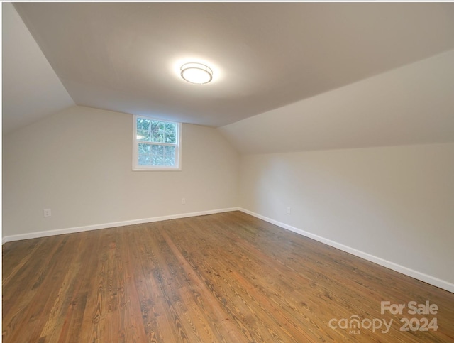 additional living space with lofted ceiling and dark hardwood / wood-style floors