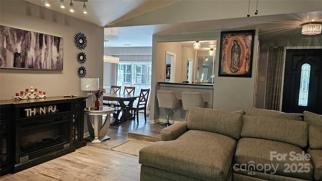 living room featuring wood-type flooring, vaulted ceiling, and ceiling fan