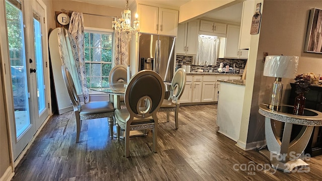 dining space featuring sink, dark hardwood / wood-style floors, and a notable chandelier