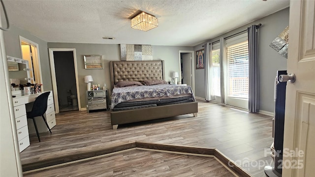 bedroom with hardwood / wood-style floors and a textured ceiling