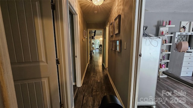 corridor featuring dark hardwood / wood-style flooring and a textured ceiling