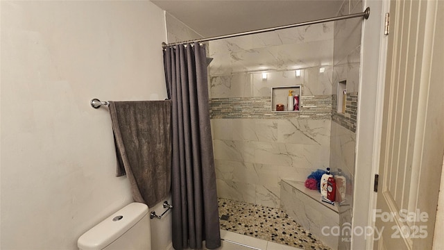 bathroom featuring curtained shower and toilet