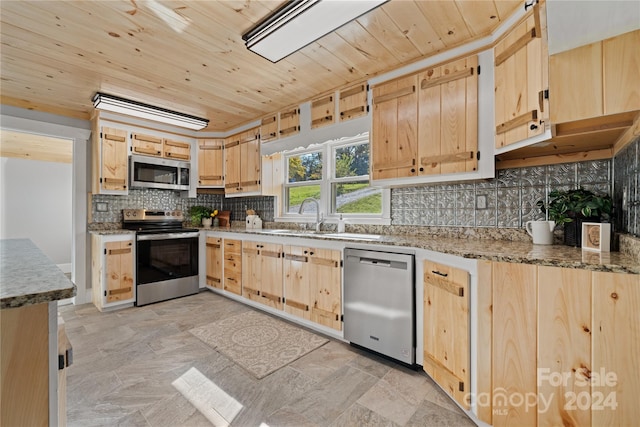 kitchen featuring appliances with stainless steel finishes, sink, light brown cabinets, and backsplash