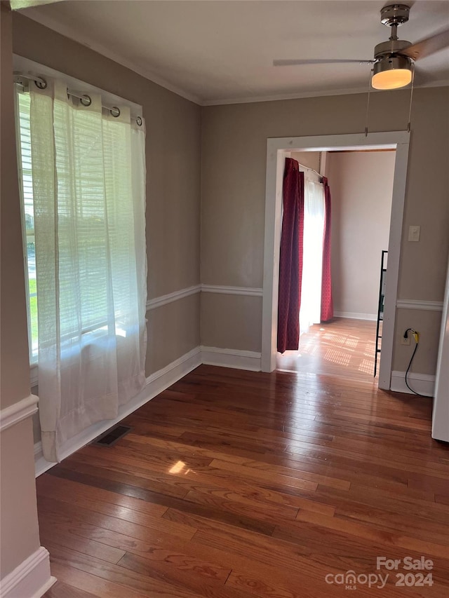 empty room featuring ceiling fan, dark hardwood / wood-style floors, and crown molding