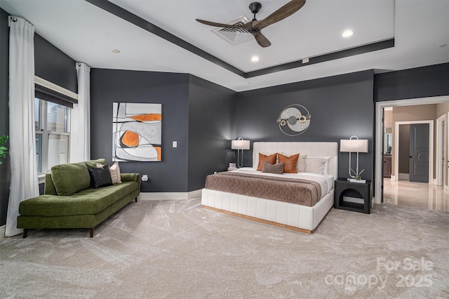 carpeted bedroom featuring a raised ceiling and ceiling fan