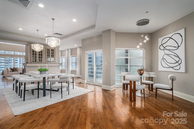 dining space with dark wood-type flooring, a chandelier, and plenty of natural light