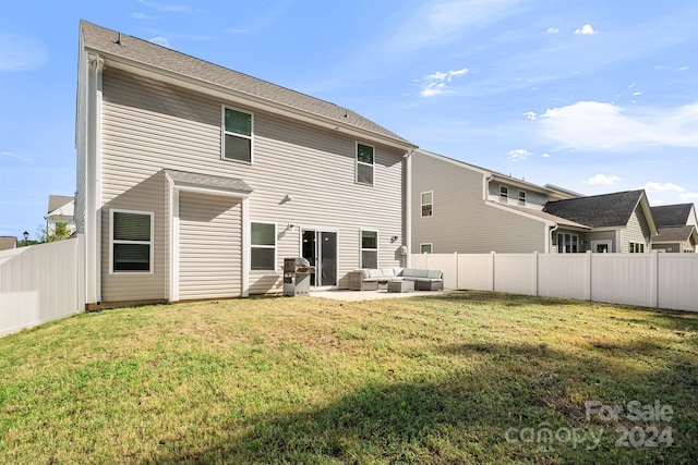 rear view of house featuring an outdoor living space, a yard, and a patio area