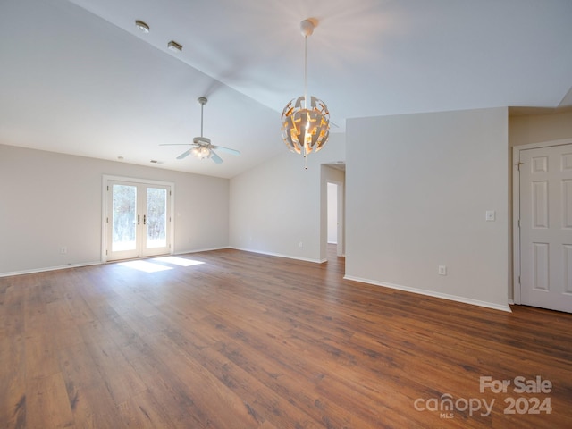 unfurnished living room featuring french doors, ceiling fan with notable chandelier, dark hardwood / wood-style floors, and vaulted ceiling