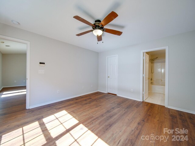 interior space featuring wood-type flooring, ensuite bathroom, and ceiling fan