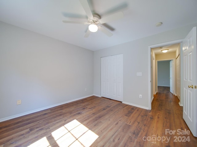 unfurnished bedroom featuring a closet, hardwood / wood-style flooring, and ceiling fan