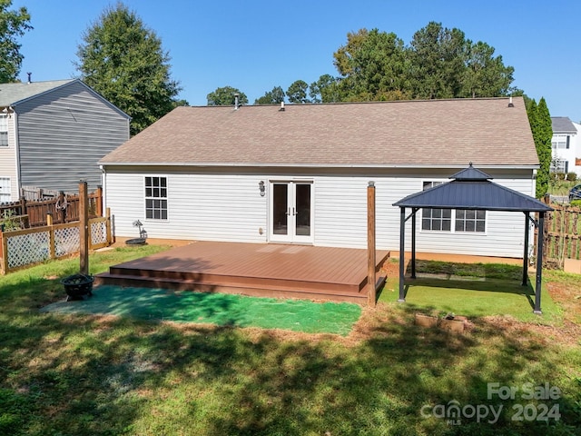 back of house with a deck and a lawn