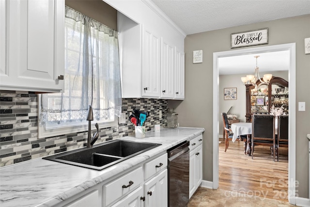 kitchen with white cabinetry, dishwasher, sink, a notable chandelier, and a textured ceiling