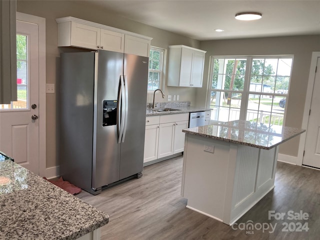 kitchen with light stone counters, white cabinets, and stainless steel appliances