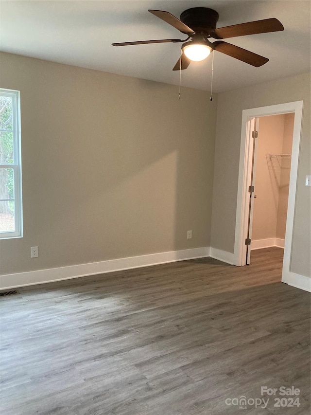 unfurnished room with ceiling fan and dark hardwood / wood-style flooring