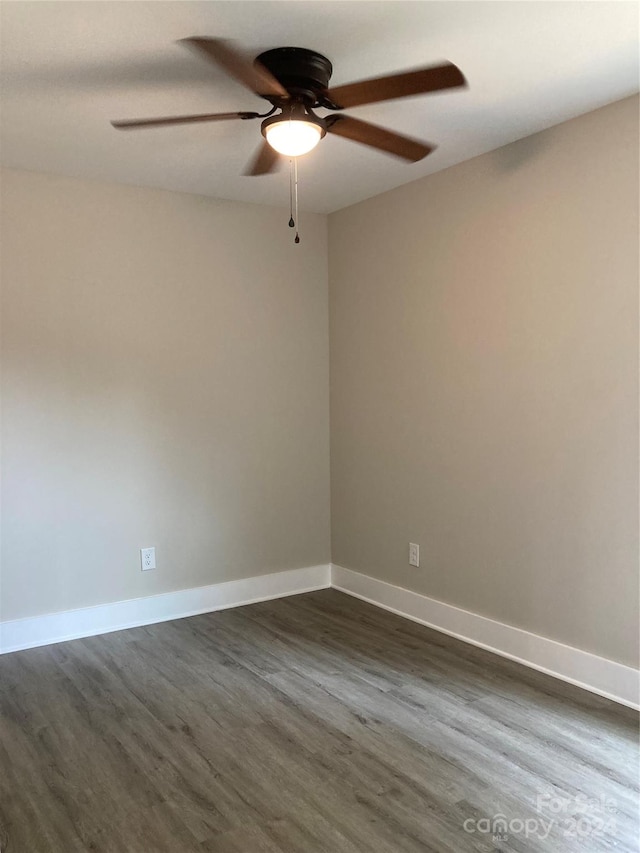 spare room with ceiling fan and dark hardwood / wood-style flooring