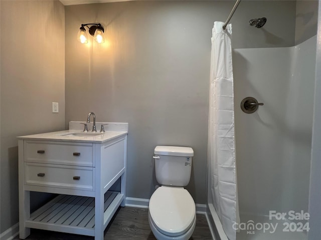 bathroom with hardwood / wood-style flooring, toilet, curtained shower, and vanity