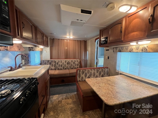 kitchen with a kitchen breakfast bar, sink, and black range with gas cooktop