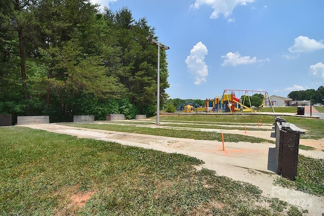 view of property's community featuring a playground and a lawn