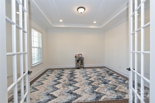 spare room with french doors, ornamental molding, a tray ceiling, and dark hardwood / wood-style floors