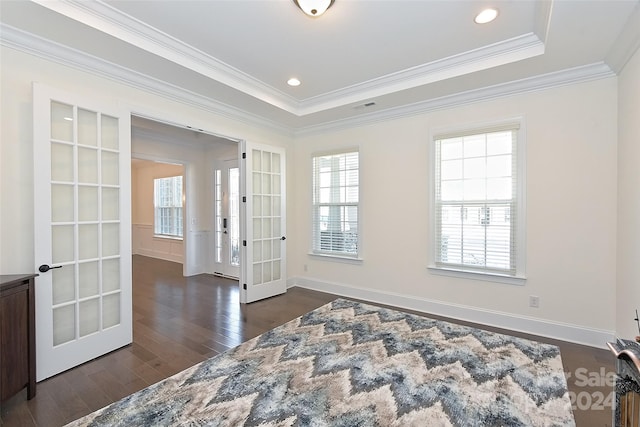 spare room with a raised ceiling, french doors, crown molding, and dark hardwood / wood-style flooring