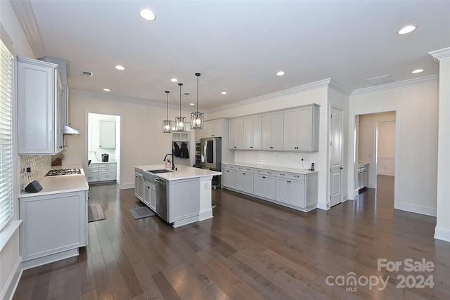 kitchen with an island with sink, backsplash, sink, decorative light fixtures, and dark hardwood / wood-style flooring