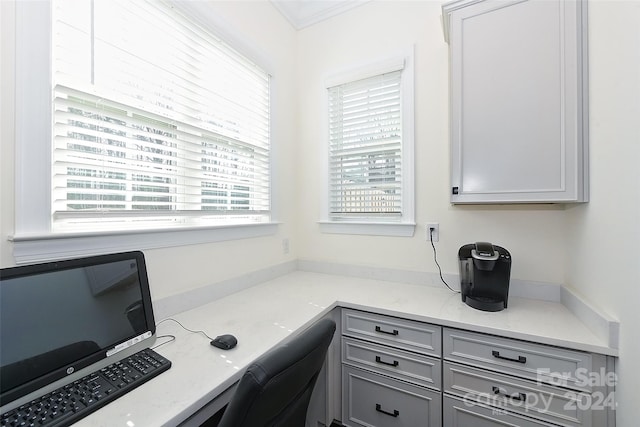 home office with built in desk and crown molding