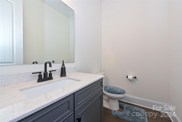 bathroom featuring vanity, hardwood / wood-style flooring, and toilet