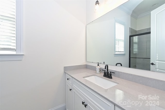 bathroom featuring vanity, crown molding, and a shower with door