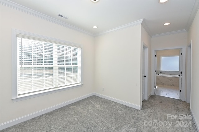 unfurnished room with crown molding and light colored carpet