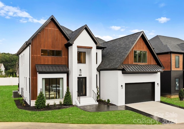 view of front of property featuring central AC, a front yard, and a garage