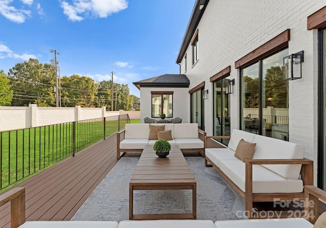 deck featuring an outdoor living space and a lawn