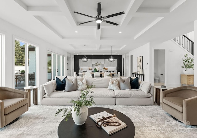 living room with coffered ceiling, beamed ceiling, and ceiling fan