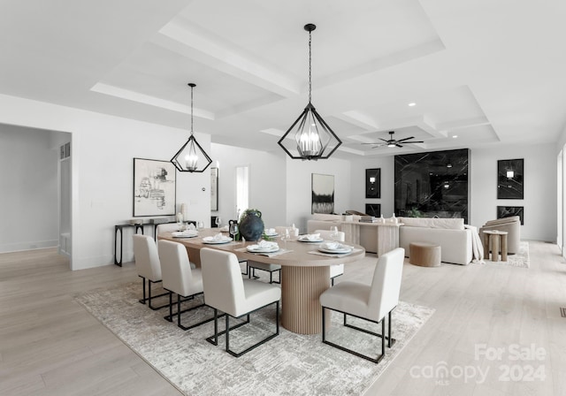 dining space featuring ceiling fan, a tray ceiling, and light hardwood / wood-style floors