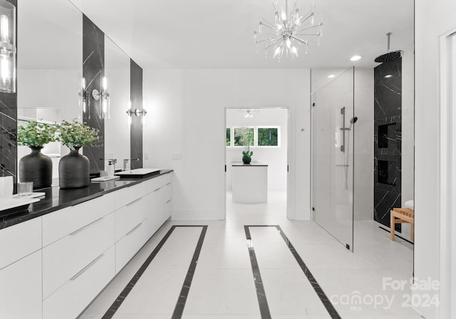 bathroom with a notable chandelier, vanity, and a shower with shower door