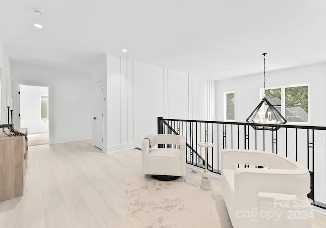 hallway featuring a notable chandelier and light hardwood / wood-style flooring