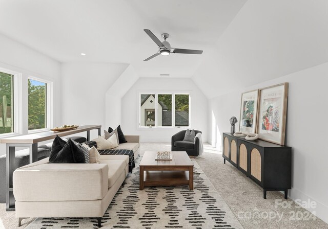 living room featuring a healthy amount of sunlight, vaulted ceiling, and light colored carpet