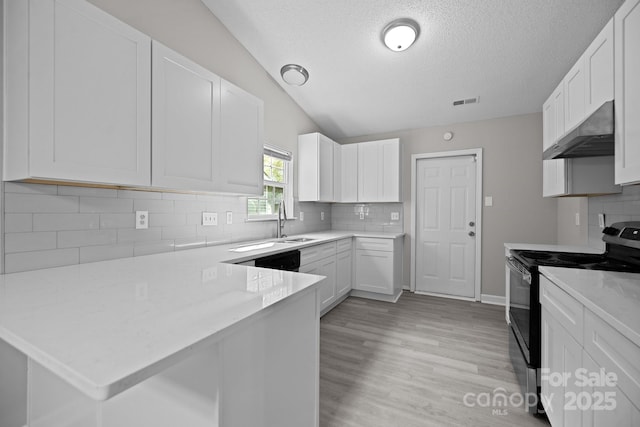 kitchen featuring ventilation hood, kitchen peninsula, vaulted ceiling, stainless steel range with electric stovetop, and white cabinets