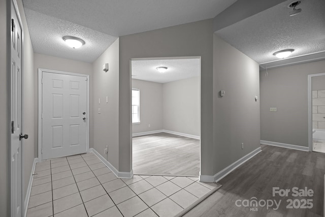 foyer featuring light tile patterned floors and a textured ceiling