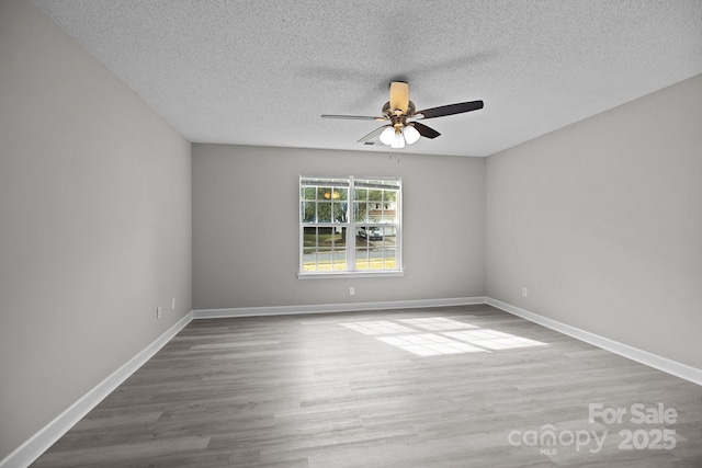 empty room with ceiling fan, hardwood / wood-style floors, and a textured ceiling