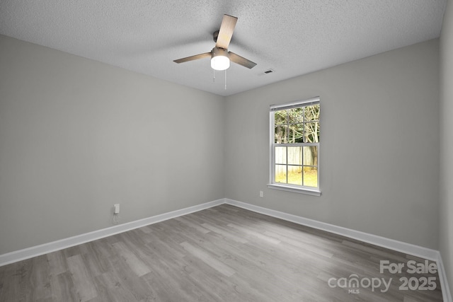 spare room with a textured ceiling, light hardwood / wood-style floors, and ceiling fan