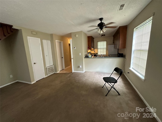 kitchen featuring white refrigerator, kitchen peninsula, a textured ceiling, ceiling fan, and dark carpet