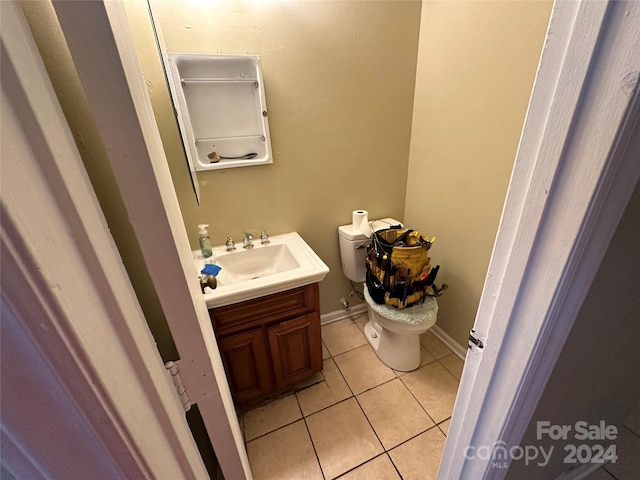 bathroom with tile patterned flooring, vanity, and toilet