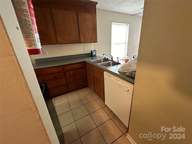 kitchen featuring white dishwasher, sink, a textured ceiling, and light tile patterned flooring