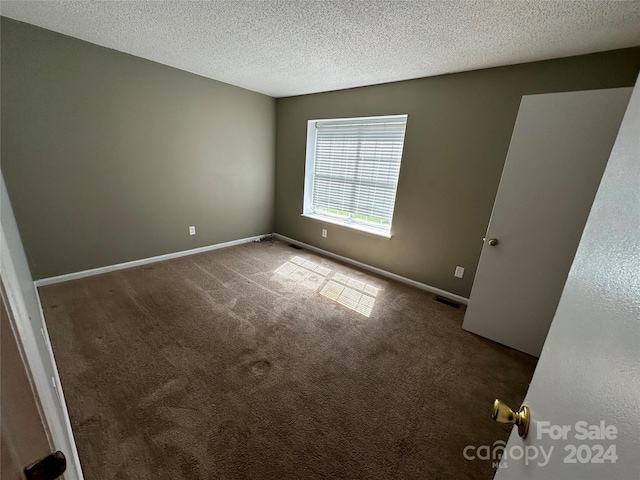 carpeted spare room with a textured ceiling