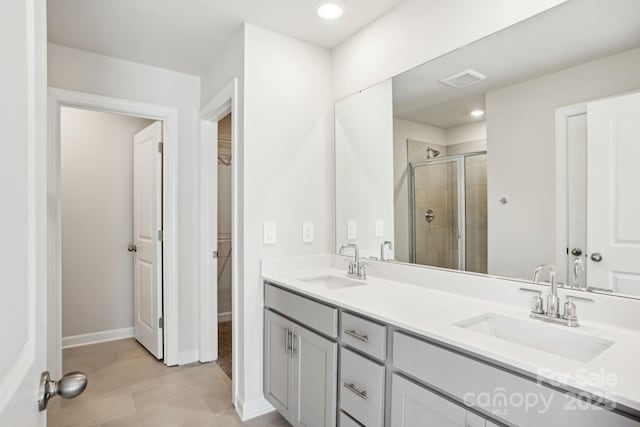 bathroom with tile patterned floors, an enclosed shower, and vanity