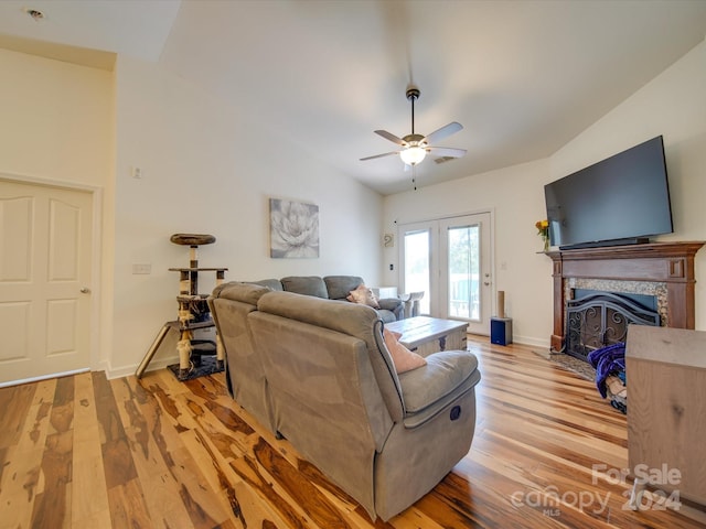 living room featuring ceiling fan, vaulted ceiling, and light hardwood / wood-style floors