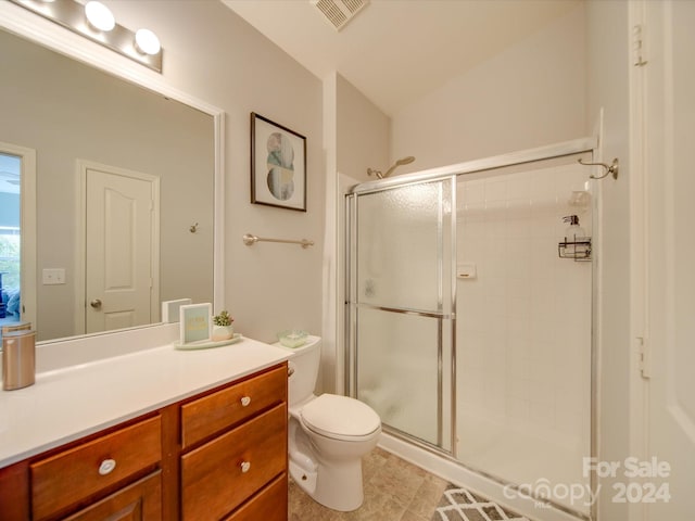 bathroom with vanity, a shower with shower door, toilet, and tile patterned floors