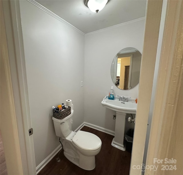 bathroom featuring ornamental molding, hardwood / wood-style flooring, and toilet